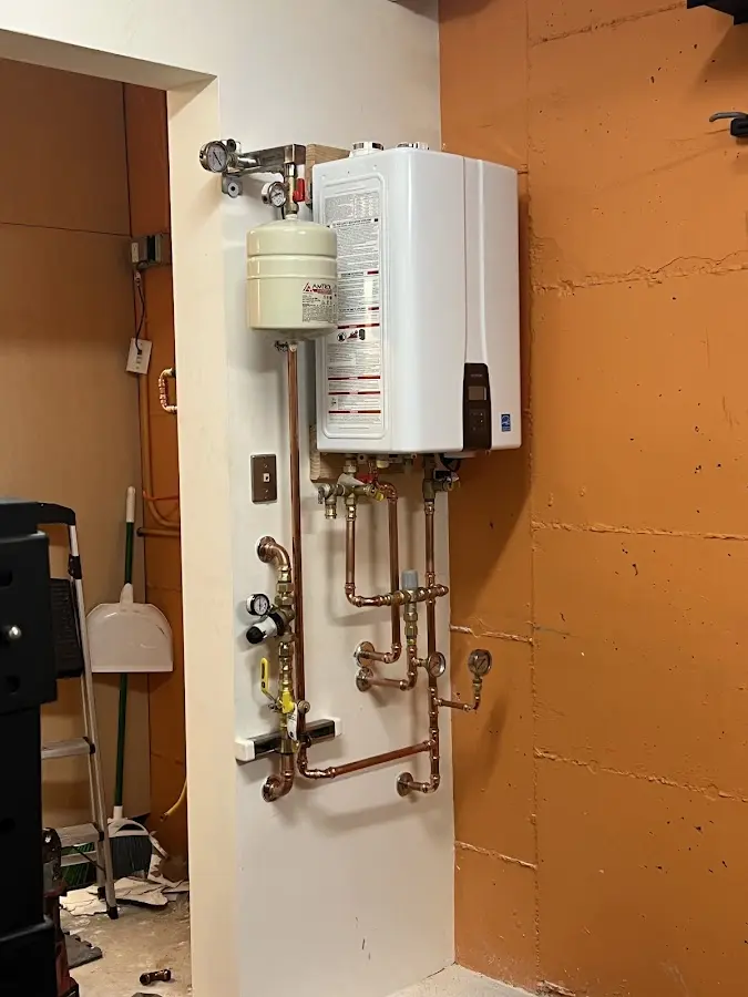 Plumbing technician inspecting water heater connections in Eveleth